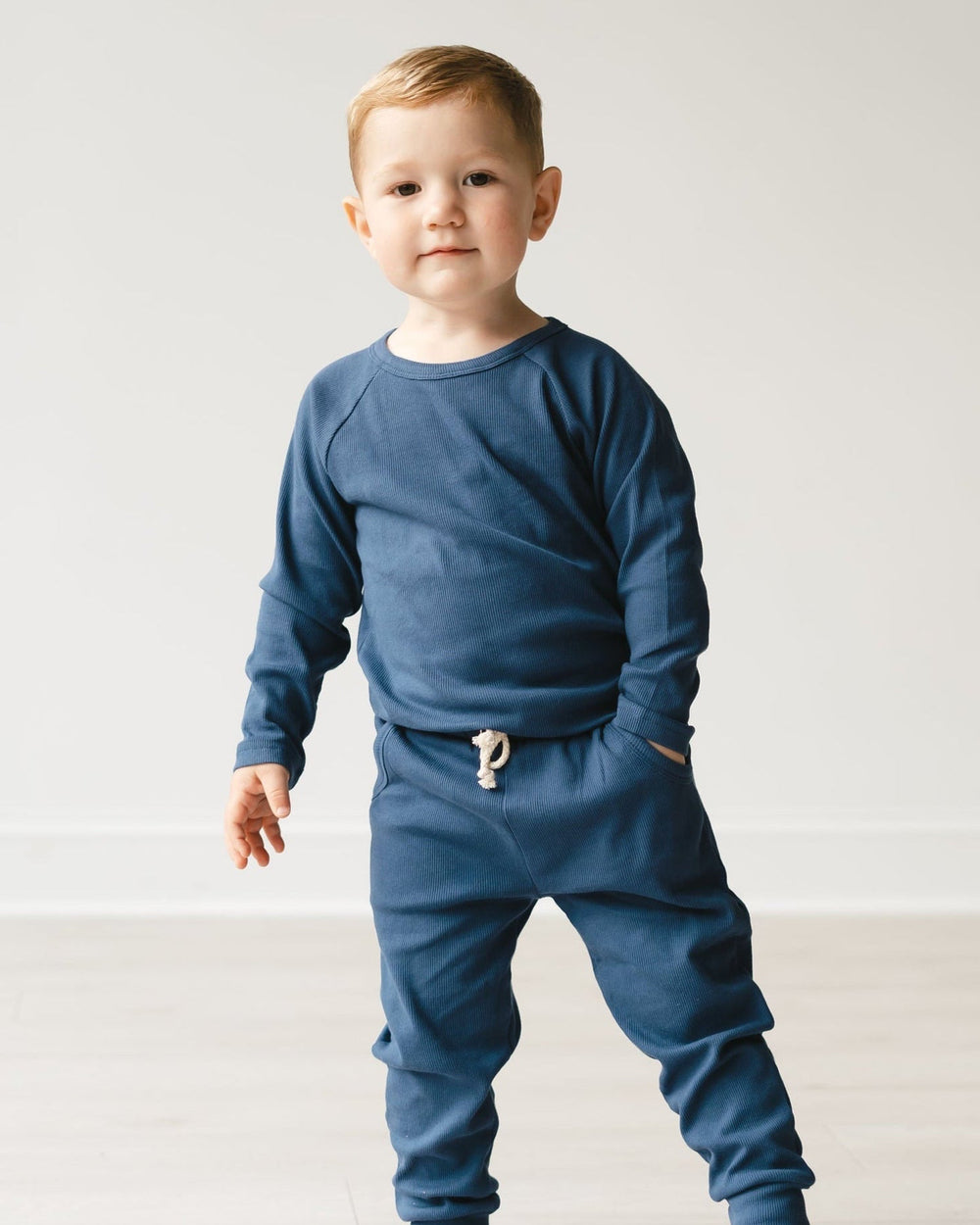 Child wearing a blue outfit with a white background